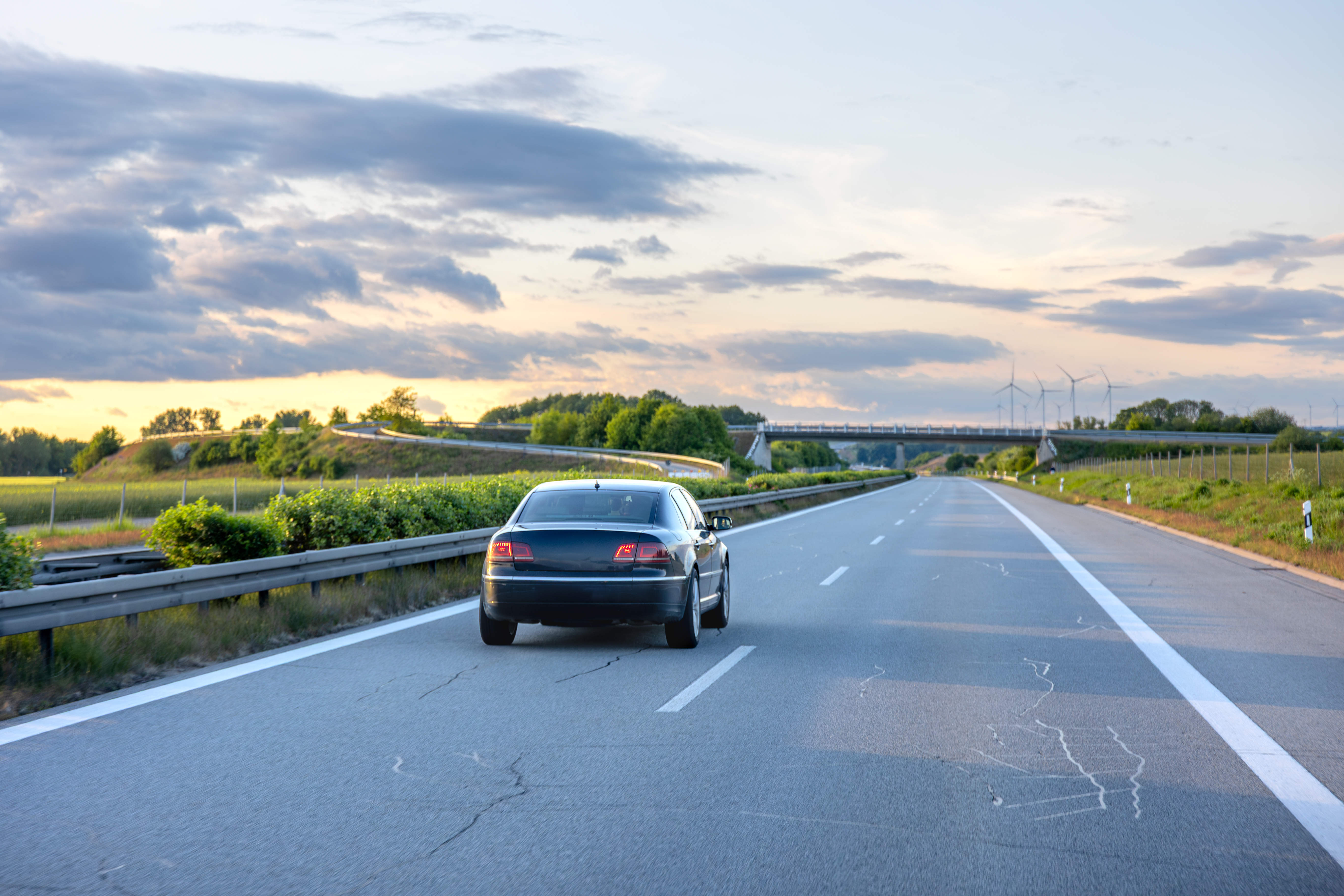 Car driving down a highway at sunset